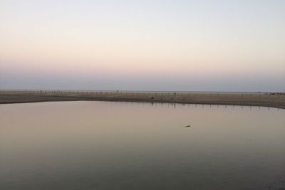 Reflection of trees in water at sunset