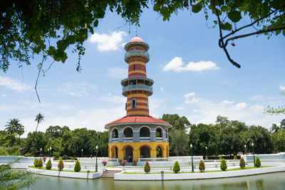 Low angle view of building beside lake against sky