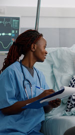 Side view of doctor examining patient in clinic