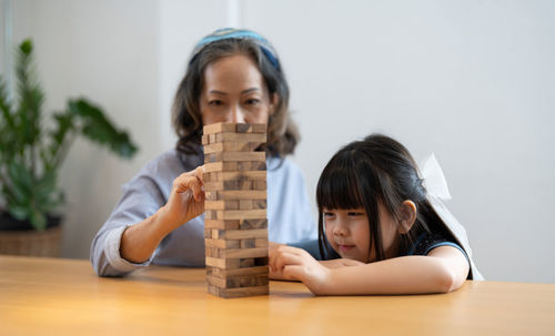 Mother and daughter playing jenga at home