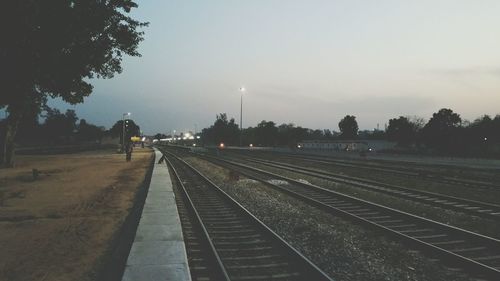 Railroad station platform against sky at dusk