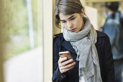 Young woman using mobile phone in tram