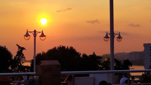 Street lights against orange sky