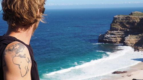 Side view of man looking at sea