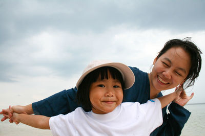 Portrait of happy friends smiling against sky