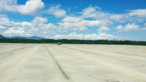 Tire tracks on road against sky