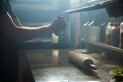 Man holding cigarette on table in kitchen