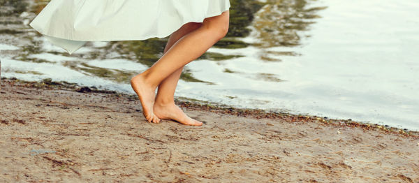 Low section of woman standing on beach