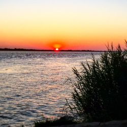 Scenic view of sea against romantic sky at sunset