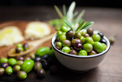 High angle view of green olives with bread on table