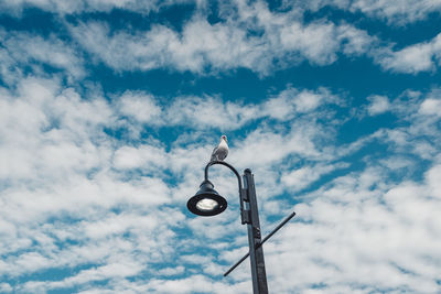 Low angle view of street light against cloudy sky