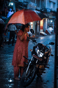 People on wet street in city during rainy season