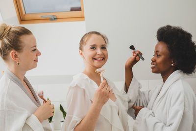 Female friends standing against white background