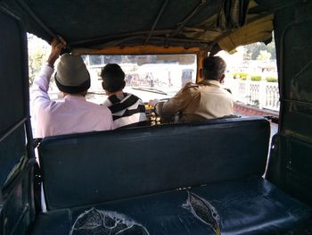 Rear view of men sitting in vehicle