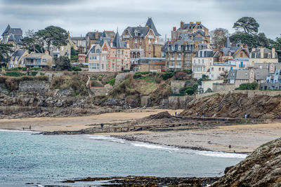 Scenic view of sea by buildings in city