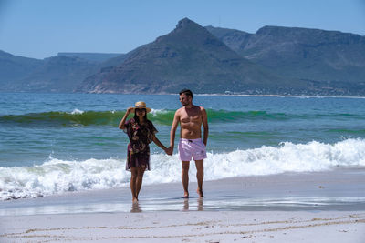 Rear view of woman standing at beach