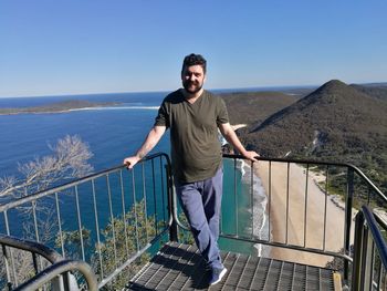 Young man standing at observation point against clear sky