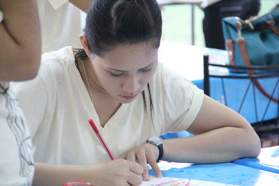 Close-up of teenage girl sitting on table