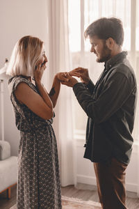 Side view of couple standing against wall