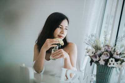 Woman holding flower at home