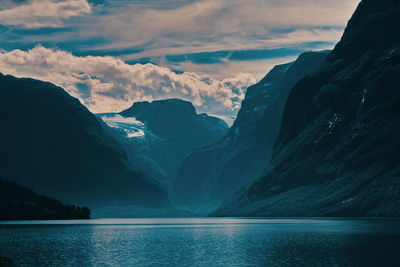 Scenic view of lake by mountains against sky