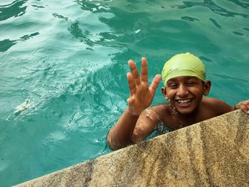 Portrait of a smiling young woman swimming in pool