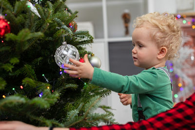 Portrait of boy decorating christmas tree