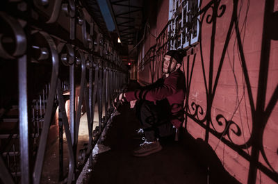 Rear view of man on illuminated street at night