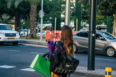 Woman with umbrella on road in city