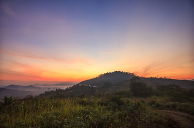 Scenic view of mountains against orange sky