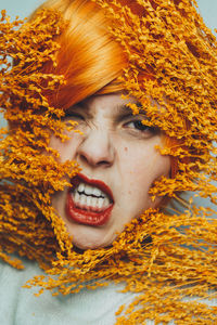 Close-up portrait of a young woman with yellow eyes closed