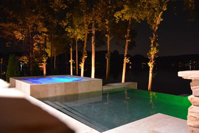 Person relaxing in swimming pool at night