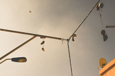 Low angle view of shoes hanging metallic poles