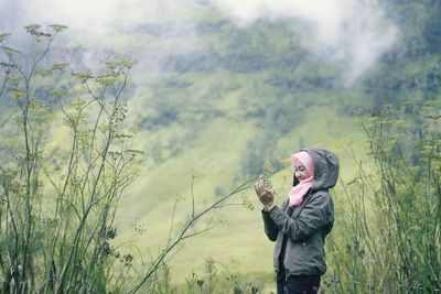 Side view of young woman standing on field