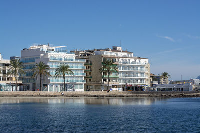 Buildings in city against clear blue sky