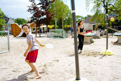 Boy and girl playing beach tennis on the sand on the beach