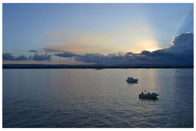 Sailboats on sea against sky during sunset