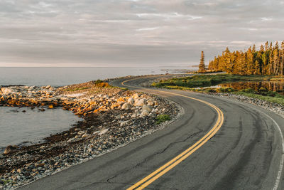 Twisting road hugs shoreline at sunrise, acadia national park, maine