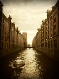 Boats in canal along buildings