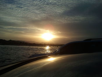 Close-up of car on sea against sky during sunset