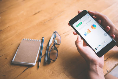 High angle view of man using smart phone on table