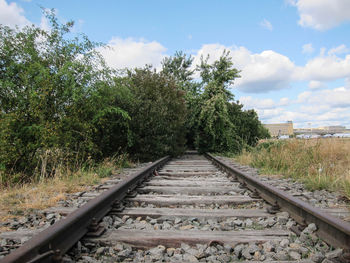 Railroad tracks amidst trees against sky