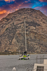 Sailboat on rock by sea against sky