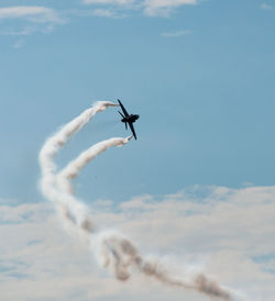 Low angle view of airplane flying against sky