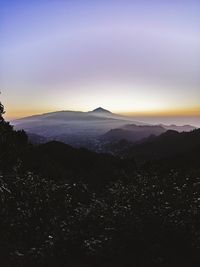 Scenic view of silhouette mountains against sky at sunset