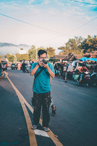 Man photographing on city street