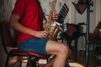 Midsection of man playing saxophone 