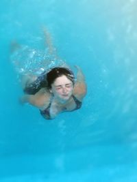 Portrait of young woman swimming in pool