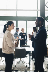 Businessman sharing ideas with female coworker in meeting at office