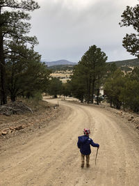 Rear view of man on road against sky